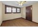 Cozy bedroom featuring hardwood floors, ceiling fan, and wood-trimmed window at 113 N Munsie St, Indianapolis, IN 46229