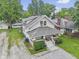 Exterior view of a two-story home with a well-maintained lawn and surrounding greenery at 113 N Munsie St, Indianapolis, IN 46229