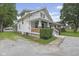 Charming two-story home with a covered porch, green lawn, and tree lined street at 113 N Munsie St, Indianapolis, IN 46229