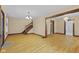 Open-concept living room featuring hardwood floors, staircase, and decorative light fixture at 113 N Munsie St, Indianapolis, IN 46229