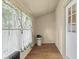 Bright, airy sunroom with wood-look floors, heater, and patterned curtains at 113 N Munsie St, Indianapolis, IN 46229