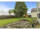 The fenced backyard with a stone patio, mature tree, and green lawn at 11532 Glenn Abbey Ln, Indianapolis, IN 46235