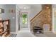 Inviting entryway featuring a brick accent wall, staircase, and an open view of the outdoors at 11532 Glenn Abbey Ln, Indianapolis, IN 46235
