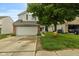 Charming two-story home with a gray exterior, brick accents, and a spacious two-car garage at 11532 Glenn Abbey Ln, Indianapolis, IN 46235