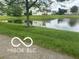 Scenic view of a pond in the community with lush green grass at 11532 Glenn Abbey Ln, Indianapolis, IN 46235