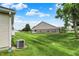 Exterior side view of home with well-kept backyard with a large, grassy lawn at 1163 Meadowlark Dr, Greenwood, IN 46143
