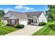 Charming single-story home with a well-manicured lawn, attached garage, and inviting front porch at 1163 Meadowlark Dr, Greenwood, IN 46143