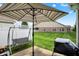 View of an outdoor patio area with an umbrella table, swing, and well-manicured lawn at 1163 Meadowlark Dr, Greenwood, IN 46143