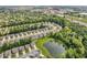 High-angle view of a neighborhood with tree-lined streets surrounding a central pond and green landscape at 1181 S Aberdeen Dr, Franklin, IN 46131