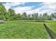 Spacious backyard with a pond, enclosed by a black metal fence, surrounded by lush greenery at 1181 S Aberdeen Dr, Franklin, IN 46131