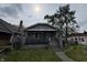 Charming stone home featuring a covered front porch and mature landscaping at 1214 Wallace Ave, Indianapolis, IN 46201