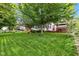 Green backyard featuring mature trees, landscaping, and decks near a lake at 12234 Limestone Dr, Fishers, IN 46037