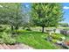 Lush backyard featuring mature trees, landscaping, and a lake view at 12234 Limestone Dr, Fishers, IN 46037
