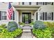 Inviting front porch adorned with lush greenery and an American flag welcomes guests to this beautiful home at 12234 Limestone Dr, Fishers, IN 46037