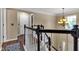 Well-lit upstairs hallway with staircase and decorative chandelier at 12234 Limestone Dr, Fishers, IN 46037