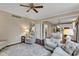 Open living space features dark hardwood floors, ceiling fan and access to kitchen at 12234 Limestone Dr, Fishers, IN 46037