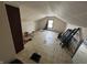 Shows a spacious attic with stained floors, slanted ceilings and a lone window at 1226 Hiatt St, Indianapolis, IN 46221