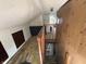 View down the stairwell leading to the attic with stained carpet, dated paneling and peeling paint at 1226 Hiatt St, Indianapolis, IN 46221