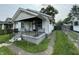 View of a modest white home with a small porch and wrought iron railings, needing some TLC and landscaping at 1226 Hiatt St, Indianapolis, IN 46221