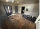Shows an unkept living room with hardwood floors and dated trim, and a peak into the next room at 1226 Hiatt St, Indianapolis, IN 46221