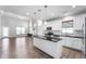 Open-concept kitchen with white cabinets, a dark island, and a clear view of the living area at 1328 Plover Dr, Greenwood, IN 46143