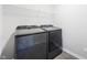 A well-lit laundry room features modern Samsung washer and dryer units with storage shelves above at 1328 Plover Dr, Greenwood, IN 46143
