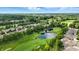 Aerial view of a residential neighborhood adjacent to a lush green golf course with tranquil ponds at 15410 Mission Hills Dr, Carmel, IN 46033