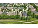 An aerial view showcases a residential neighborhood with mature trees and curved roads at 15410 Mission Hills Dr, Carmel, IN 46033