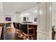 Basement wet bar with wooden bar and seating, complemented by elegant trim and a view of game area at 15410 Mission Hills Dr, Carmel, IN 46033