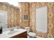 Charming powder room featuring patterned wallpaper, a decorative mirror, and a white vanity at 15410 Mission Hills Dr, Carmel, IN 46033
