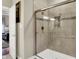 This updated bathroom features a tiled shower with glass doors and neutral tones for a spa-like feel at 15410 Mission Hills Dr, Carmel, IN 46033