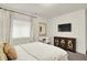 Stylish bedroom featuring a gold mirror, modern decor, and mounted TV at 15410 Mission Hills Dr, Carmel, IN 46033
