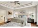 Comfortable bedroom offers a ceiling fan, large windows, artwork, and hardwood flooring at 15410 Mission Hills Dr, Carmel, IN 46033