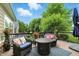 Outdoor deck with seating, a fire pit, and a view of the treed yard at 15410 Mission Hills Dr, Carmel, IN 46033