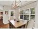 Dining room features a chandelier, dining table with seating for six, and large windows providing ample natural light at 15410 Mission Hills Dr, Carmel, IN 46033