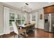 Bright dining room features a wood table with seating and a stylish chandelier at 15410 Mission Hills Dr, Carmel, IN 46033