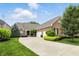 Charming brick home with a large driveway, well-manicured lawn, and lush landscaping at 15410 Mission Hills Dr, Carmel, IN 46033