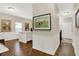 Hallway boasts hardwood floors and wainscotting, creating a bright and inviting transition at 15410 Mission Hills Dr, Carmel, IN 46033