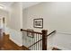 Spacious hallway featuring hardwood floors, decorative wainscoting, and natural light from an open doorway at 15410 Mission Hills Dr, Carmel, IN 46033
