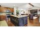 Open concept kitchen with granite island and view to the living room featuring vaulted ceilings and hardwood floors at 15410 Mission Hills Dr, Carmel, IN 46033