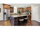 Well-lit kitchen features wood floors, stainless steel appliances, granite countertops, kitchen island, and barstool seating at 15410 Mission Hills Dr, Carmel, IN 46033