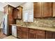 Kitchen area features granite countertops, stainless steel appliances, natural stone backsplash, and brown wood cabinets at 15410 Mission Hills Dr, Carmel, IN 46033