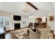 Bright living room with vaulted ceiling, fireplace, and view of the kitchen area at 15410 Mission Hills Dr, Carmel, IN 46033
