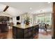 Open concept kitchen with granite island and view to the living room, fireplace and dining room at 15410 Mission Hills Dr, Carmel, IN 46033