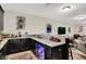 Wet bar with granite countertops, bar fridge, dark wood cabinetry, decor, and view of the finished basement at 15410 Mission Hills Dr, Carmel, IN 46033