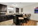 Stylish wet bar features dark cabinetry, granite countertops, sink, and seating, perfect for entertaining guests at 15410 Mission Hills Dr, Carmel, IN 46033