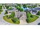 Aerial view of home with lush landscaping, circular driveway, and situated near a pond in the neighborhood at 15529 Mission Hills Dr, Carmel, IN 46033