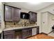 Wet bar features granite counters, mosaic backsplash, beverage cooler, stainless dishwasher and a mounted flat screen TV at 15529 Mission Hills Dr, Carmel, IN 46033