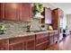 Kitchen detail showcasing granite countertops, stainless steel appliances, wood cabinets, and tiled backsplash at 15529 Mission Hills Dr, Carmel, IN 46033