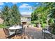 Outdoor patio features a stone fireplace, dining table, and comfortable seating at 15529 Mission Hills Dr, Carmel, IN 46033